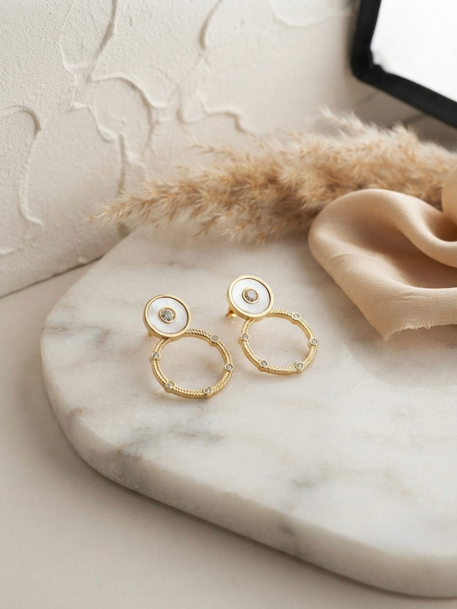Circular mother-of-pearl and crystal studs.