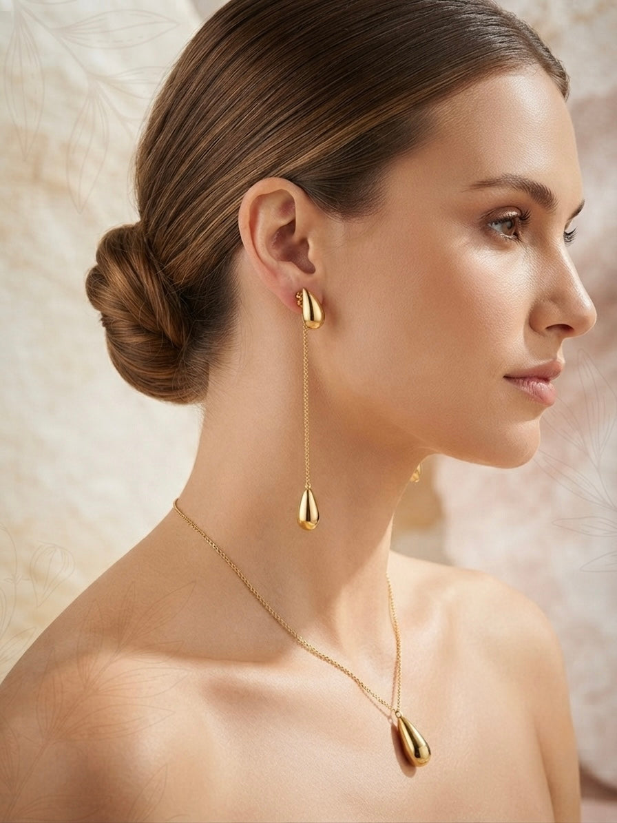 Sleek polished gold teardrop chain earrings.