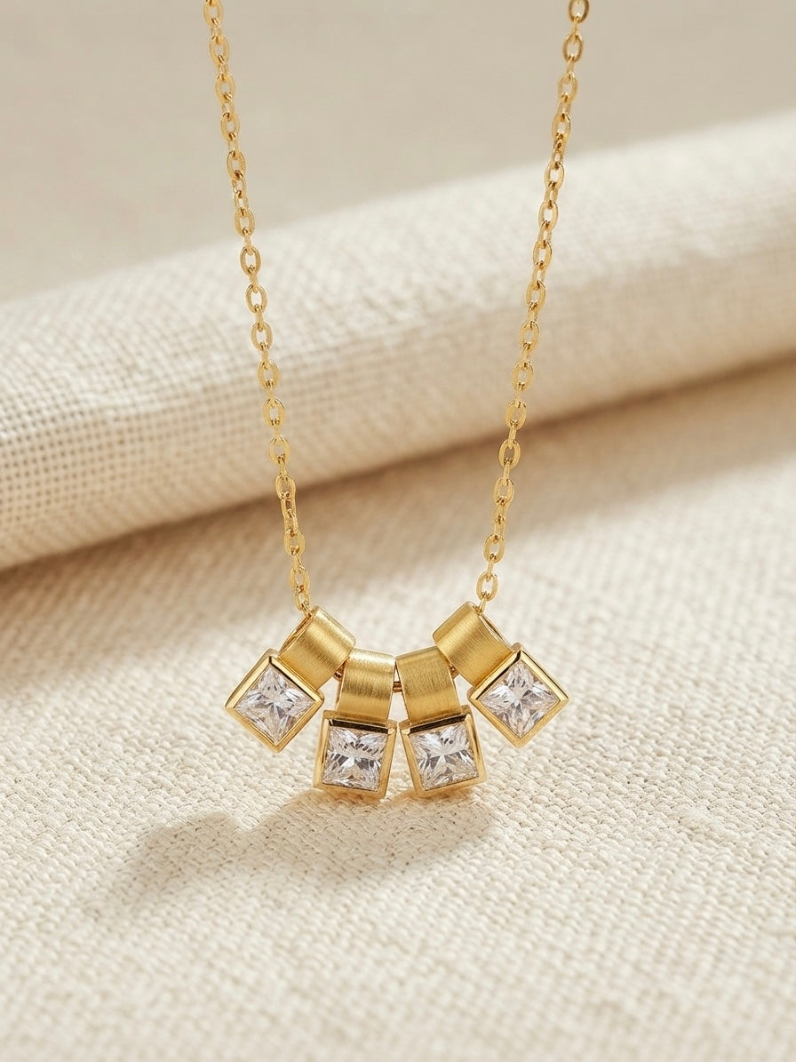 Gold four crystal square charm slider necklace.
