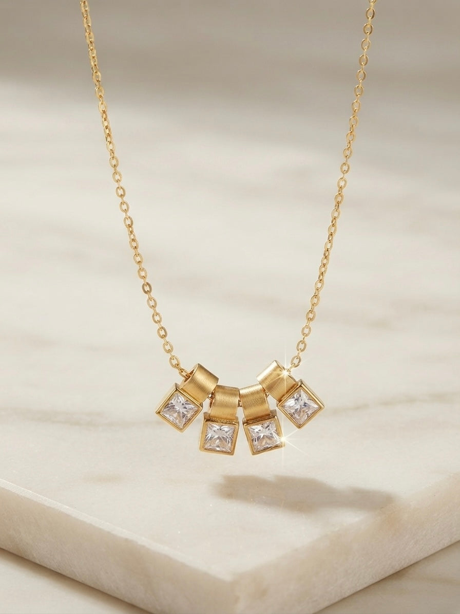 Gold four crystal square charm slider necklace.