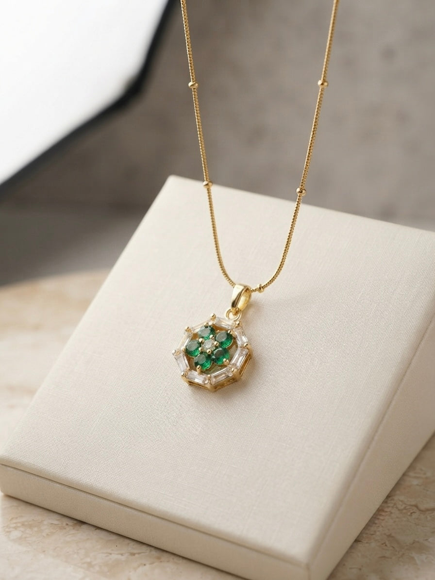 Geometric emerald floral pendant on chain.
