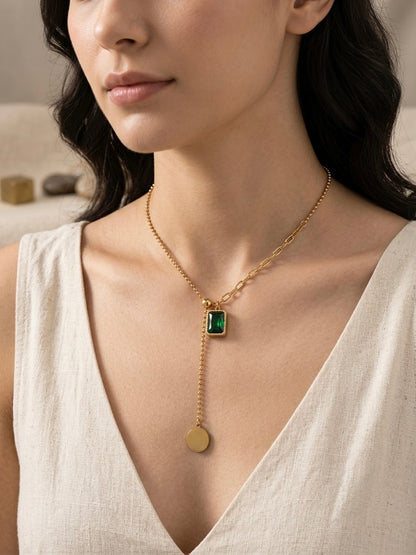 Gold dual-chain necklace with emerald drop.