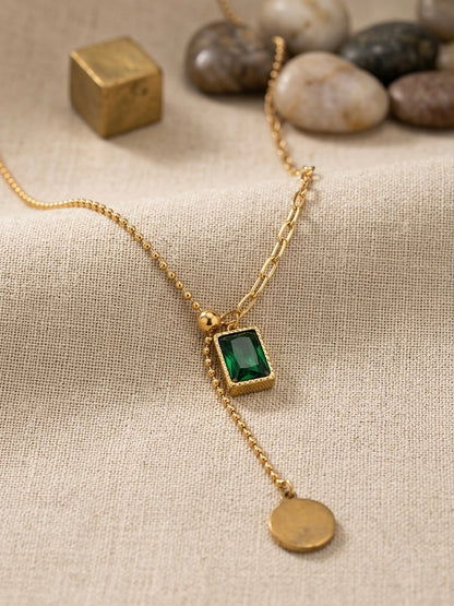 Gold dual-chain necklace with emerald drop.