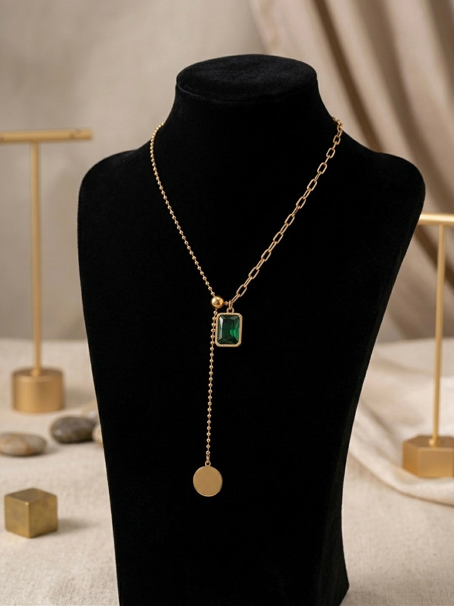 Gold dual-chain necklace with emerald drop.