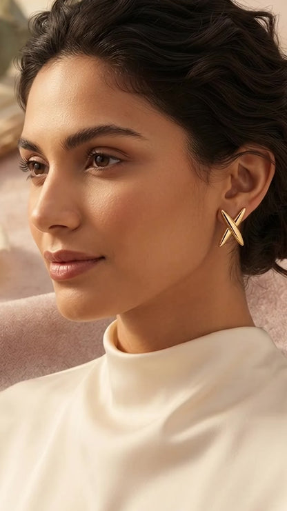 Modern geometric cross gold stud earrings.