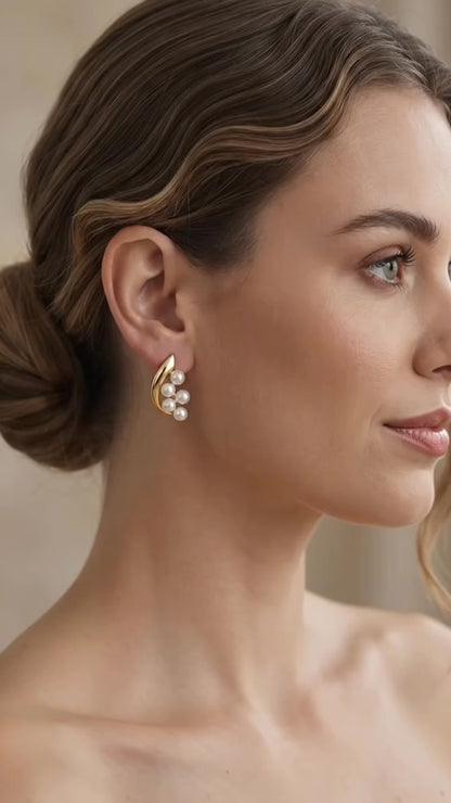 Elegant gold crescent pearl stud earrings.