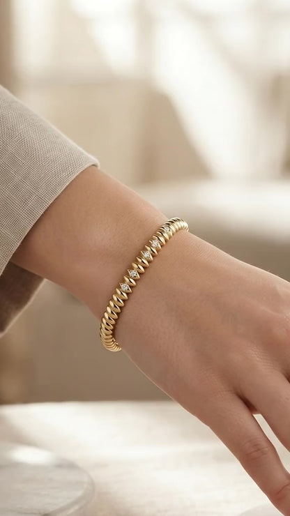 Elegant ridged stone-accented gold bangle.