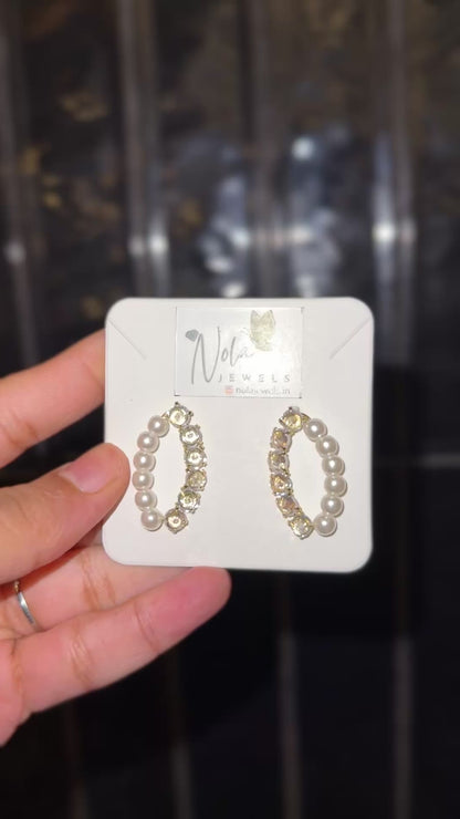 Sophisticated hoop earrings with luminous pearls.
