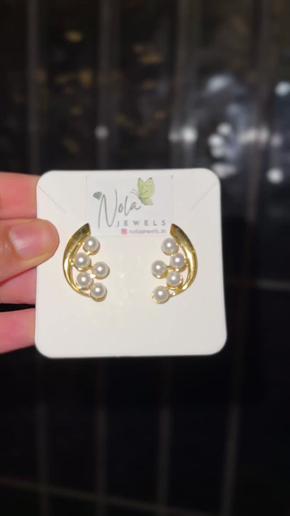 Elegant gold crescent pearl stud earrings.
